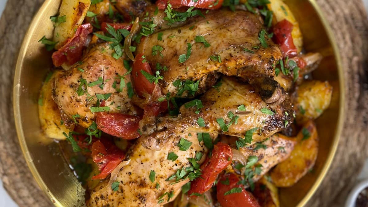Illustrative stock photo of roast chicken with red peppers and potatoes in a pan.